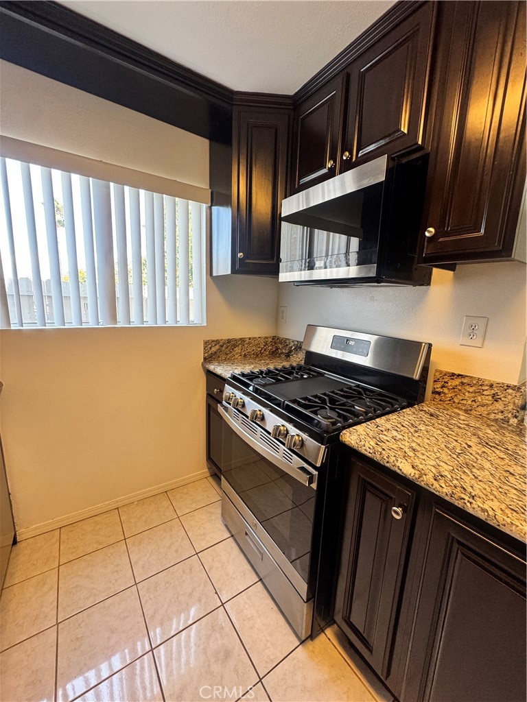 2255 Cahuilla Street, Unit 140 Colton, CA 92324 - Photo 3 of 9 a kitchen with granite countertop a stove top oven microwave and cabinets