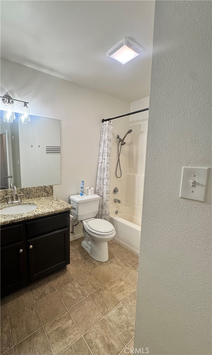 2255 Cahuilla Street, Unit 140 Colton, CA 92324 - Photo 8 of 9 a bathroom with a granite countertop toilet sink and a mirror