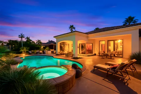 a view of a swimming pool with lounge chairs in patio
