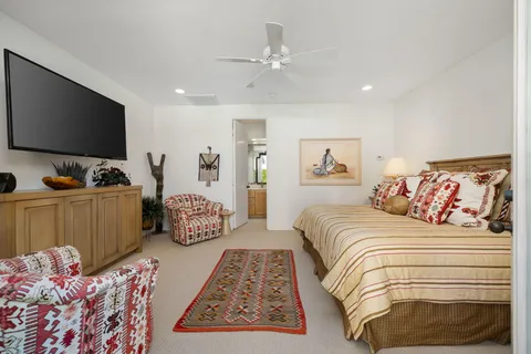 a bedroom with a large bed and a flat screen tv