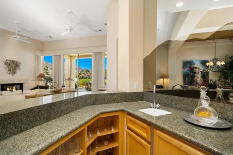 a large kitchen with granite countertop a sink and a window