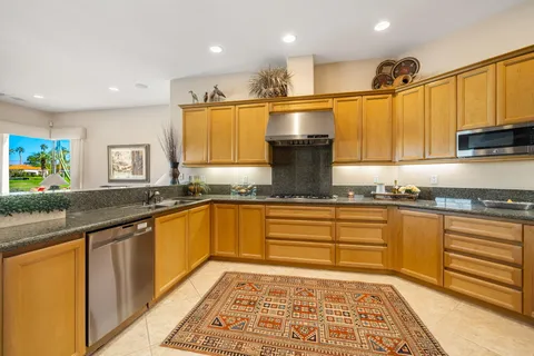 a large kitchen with stainless steel appliances granite countertop a sink and cabinets