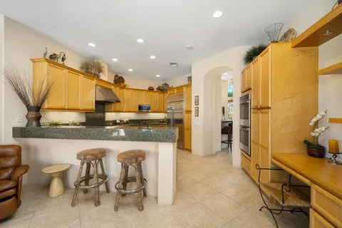 a large kitchen with kitchen island a large counter top space a sink stainless steel appliances and cabinets