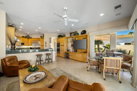 a living room with furniture kitchen view and a large window
