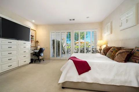 a bedroom with a bed and flat screen tv