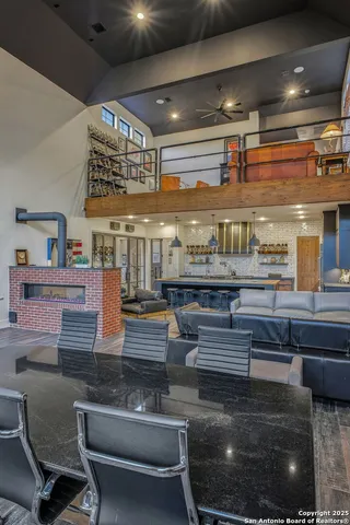 a dining room with stainless steel appliances kitchen island granite countertop a table chairs and a view of living room