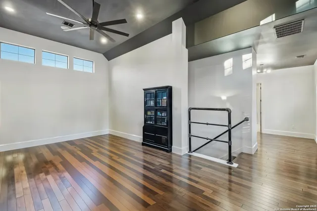 a living room with furniture a ceiling fan and a large window