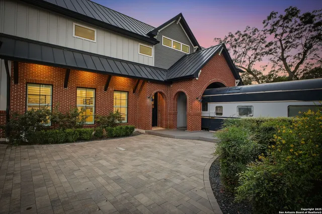 a view of a house with large windows and a yard