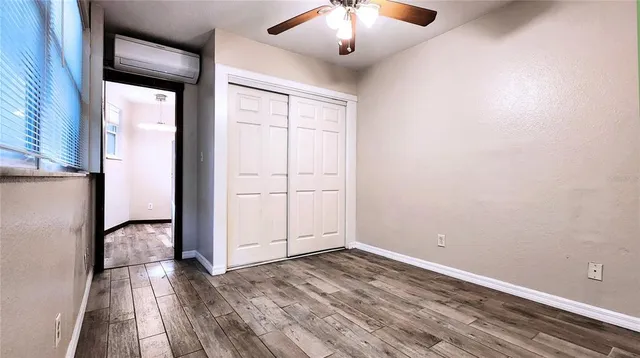 an empty room with wooden floor and chandelier