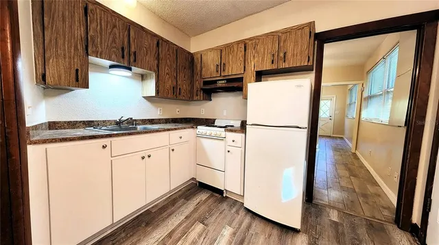 a kitchen with sink refrigerator and cabinets