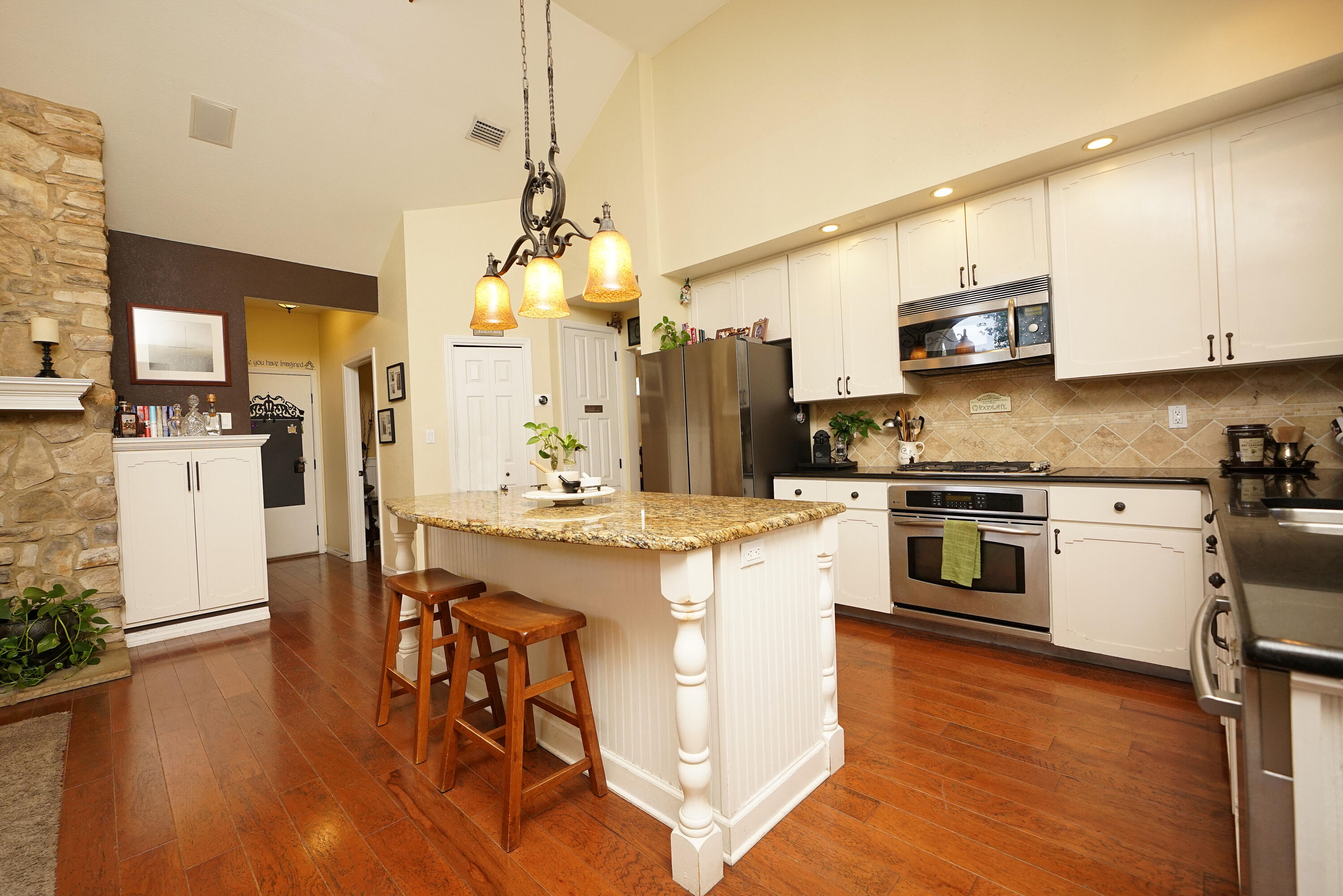 941 Ruckel Drive Niceville, FL 32578 - Photo 20 of 57 a kitchen with stainless steel appliances kitchen island wooden floors and white cabinets