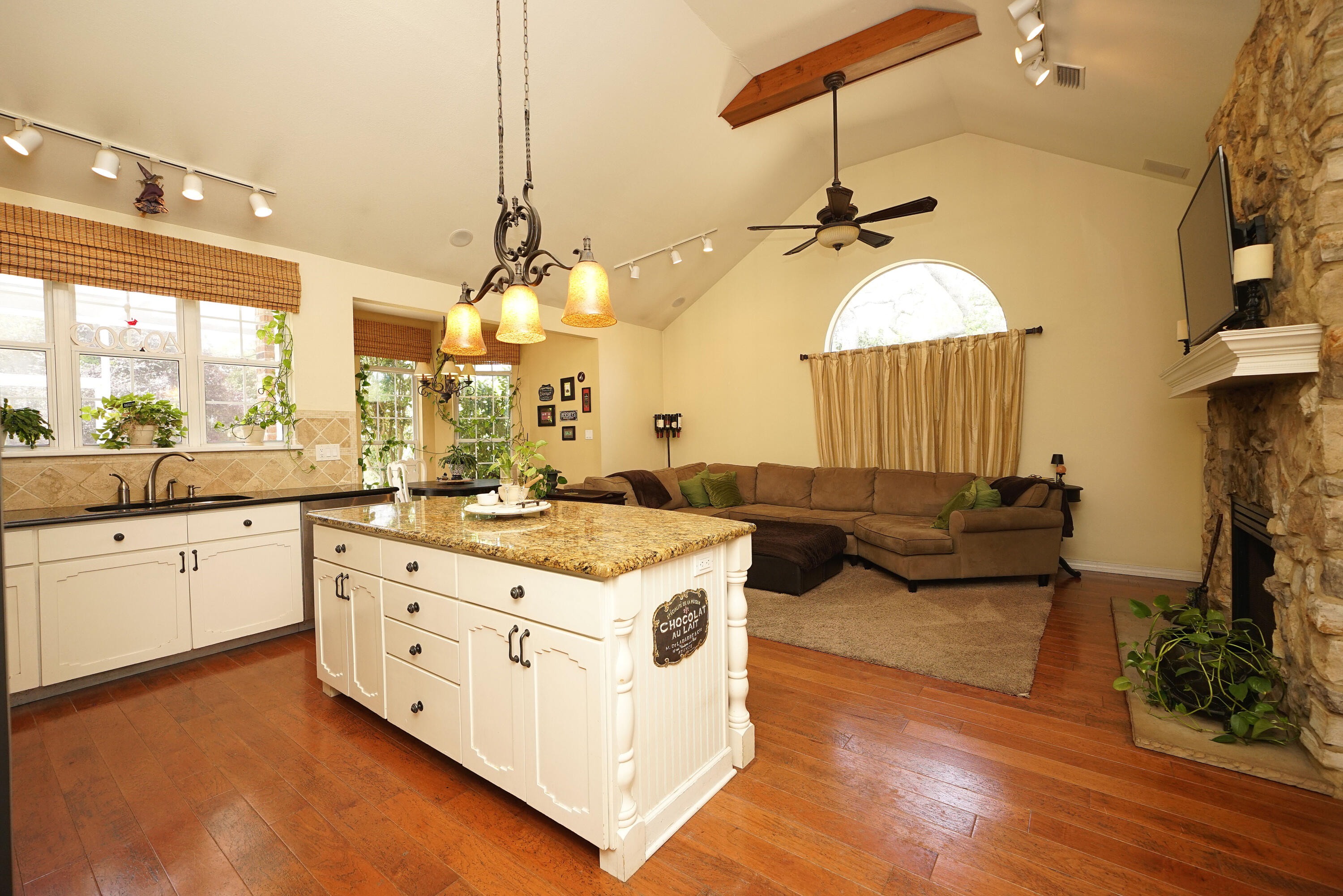 941 Ruckel Drive Niceville, FL 32578 - Photo 22 of 57 a kitchen with kitchen island granite countertop a stove a sink dishwasher and a fireplace with wooden floor