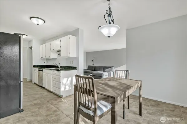 a kitchen with stainless steel appliances a table chairs and a refrigerator