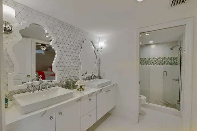 a bathroom with a double vanity sink mirror and shower