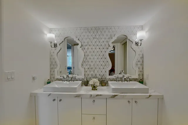 a bathroom with double sink and two mirror