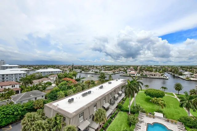 an aerial view of a city with lots of residential buildings ocean and mountain view in back
