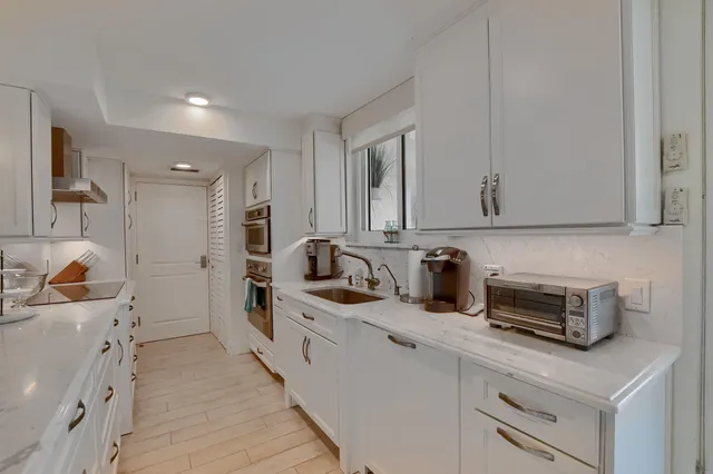 a kitchen with granite countertop a sink stove and cabinets