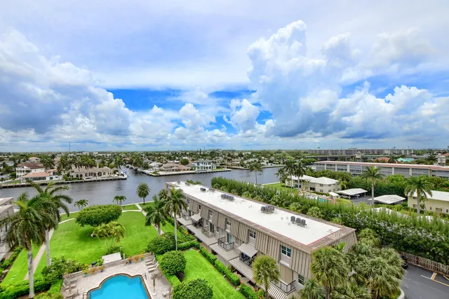 an aerial view of a city with lots of residential buildings ocean and mountain view in back