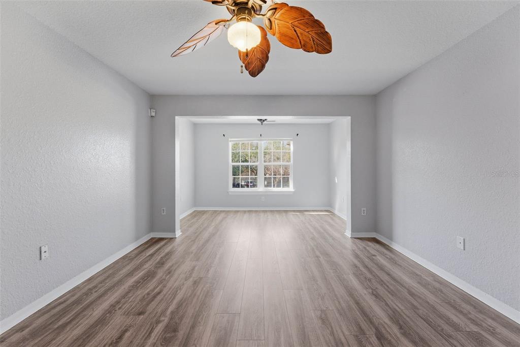 5479 Vineland Road, Unit 9202 Orlando, FL 32811 - Photo 14 of 31 a view of an empty room with wooden floor and a window