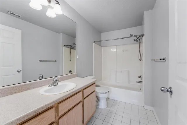 a bathroom with a granite countertop sink a toilet and shower