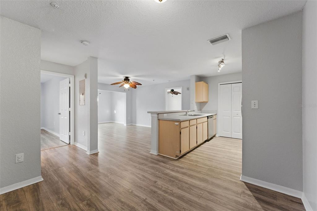 5479 Vineland Road, Unit 9202 Orlando, FL 32811 - Photo 4 of 31 a kitchen with wooden floors and cabinets