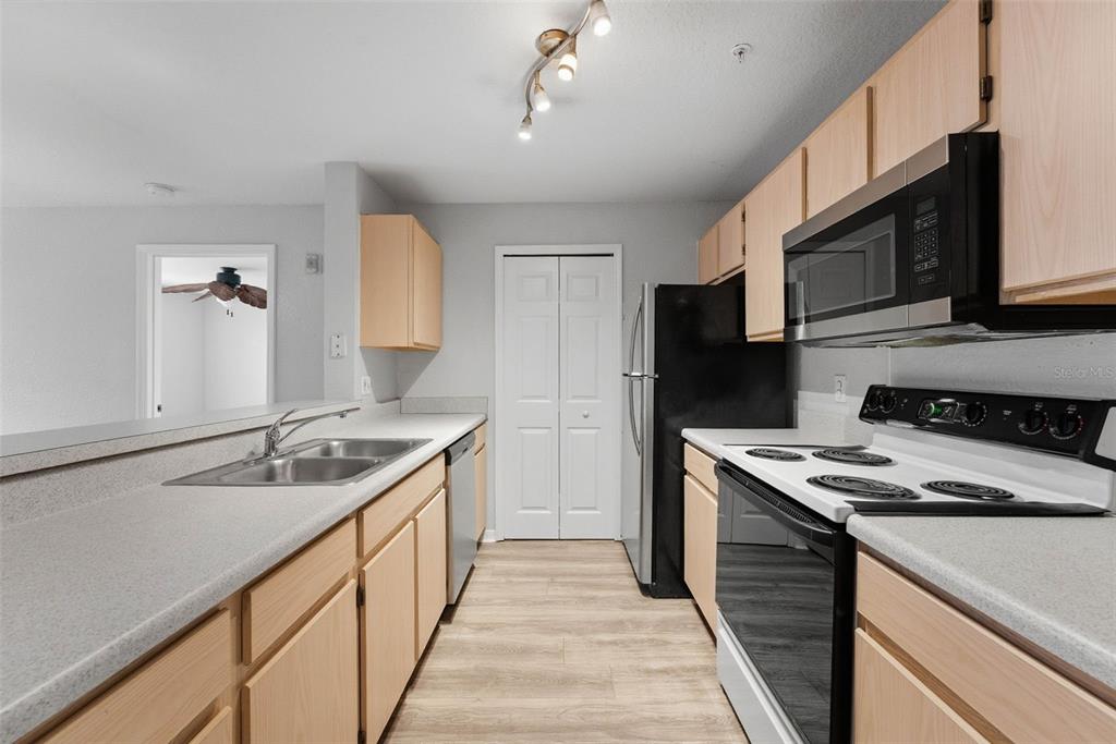 5479 Vineland Road, Unit 9202 Orlando, FL 32811 - Photo 7 of 31 a kitchen with stainless steel appliances granite countertop a sink stove and refrigerator