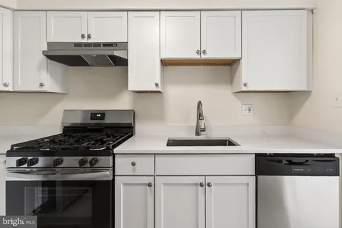 a kitchen with stainless steel appliances granite countertop a sink a stove and cabinets