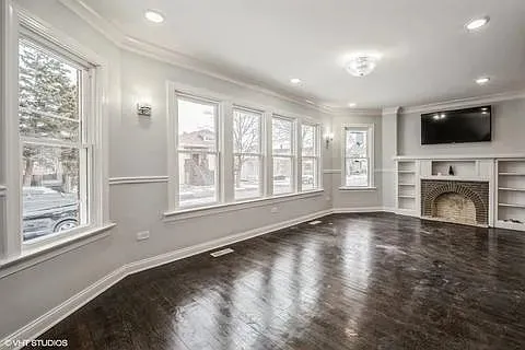 a view of an empty room with window and fire place