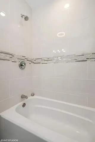 a bathroom with a white bath tub and a shower
