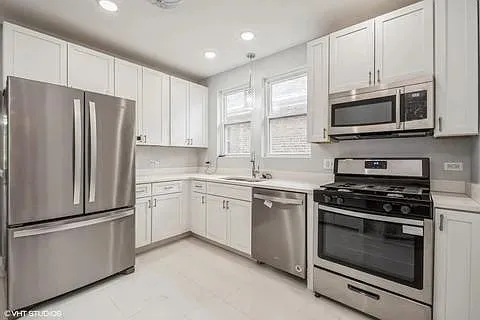 a kitchen with stainless steel appliances white cabinets white stove and a refrigerator