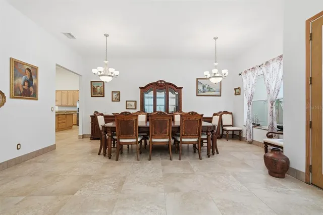 a living room with furniture kitchen view and a chandelier