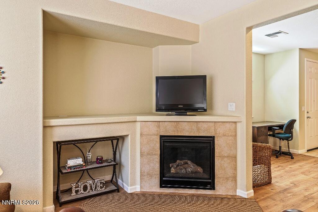 1864 Wind Ranch Road, Unit B Reno, NV 89521 - Photo 11 of 42 a living room with a fireplace and a flat screen tv