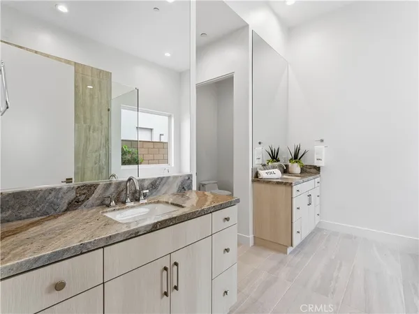 a bathroom with a sink a toilet and mirror