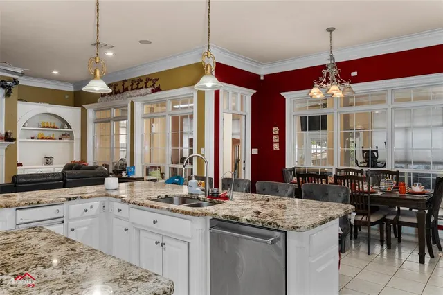 a large kitchen with granite countertop a sink and cabinets