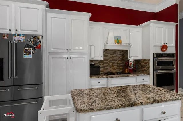 a kitchen with stainless steel appliances kitchen island granite countertop a refrigerator and microwave