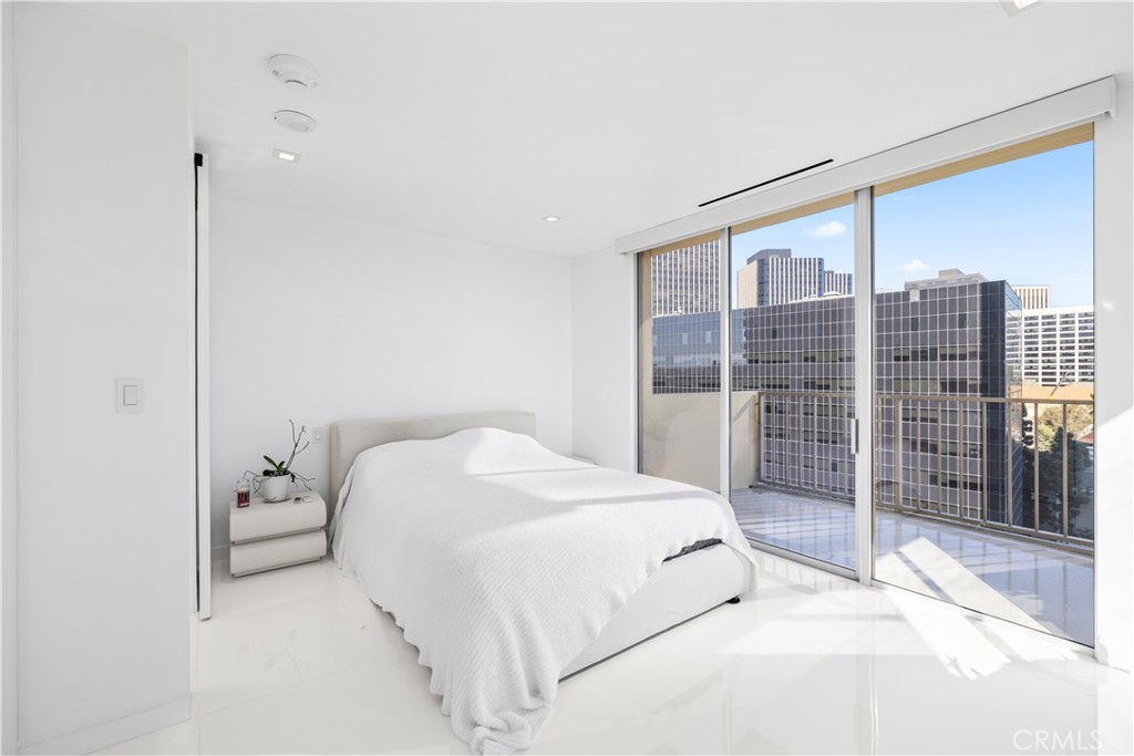 2160 Century Park East, Unit 902 Los Angeles, CA 90067 - Photo 22 of 51 a bedroom with a large bed and a chandelier