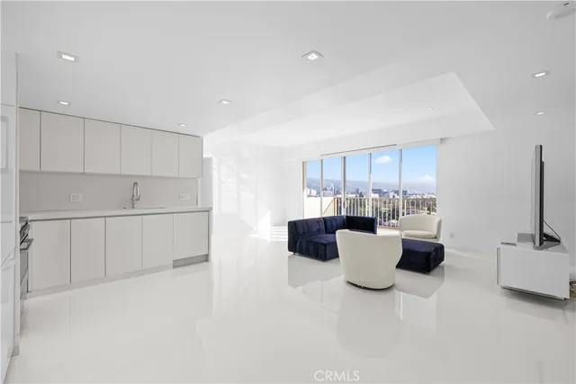a living room with furniture a window and a kitchen view