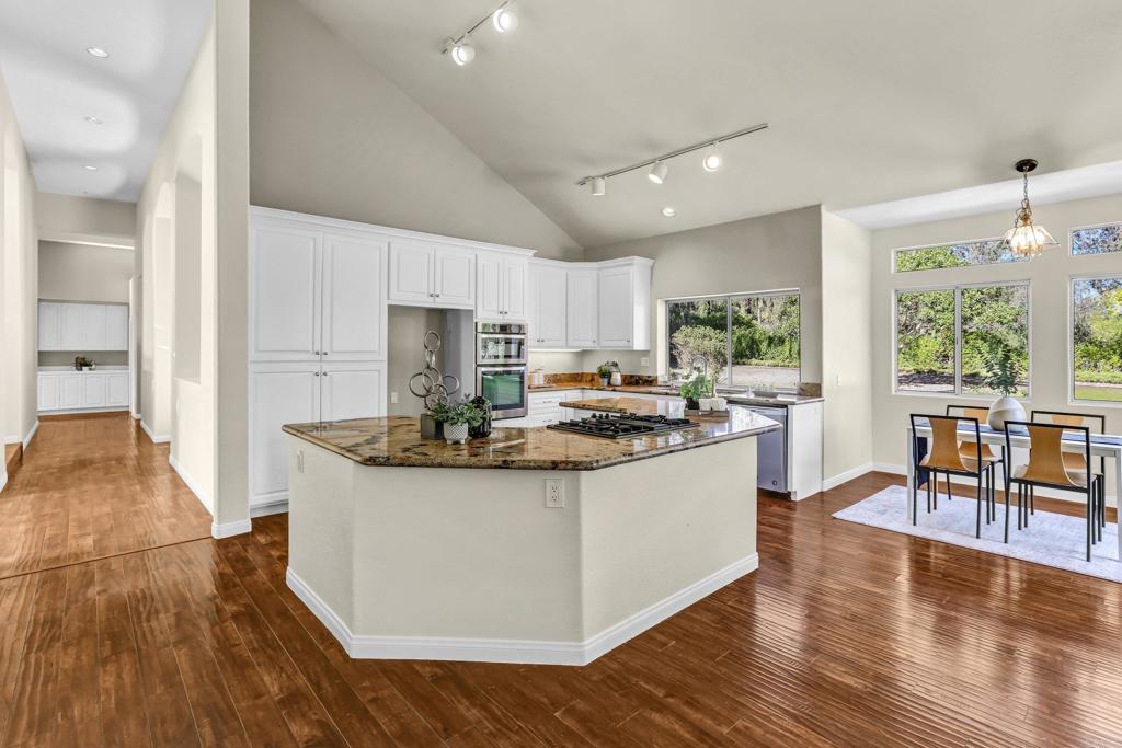 12236 Malabar Drive Poway, CA 92064 - Photo 13 of 32 a kitchen with stainless steel appliances granite countertop wooden floors and white cabinets