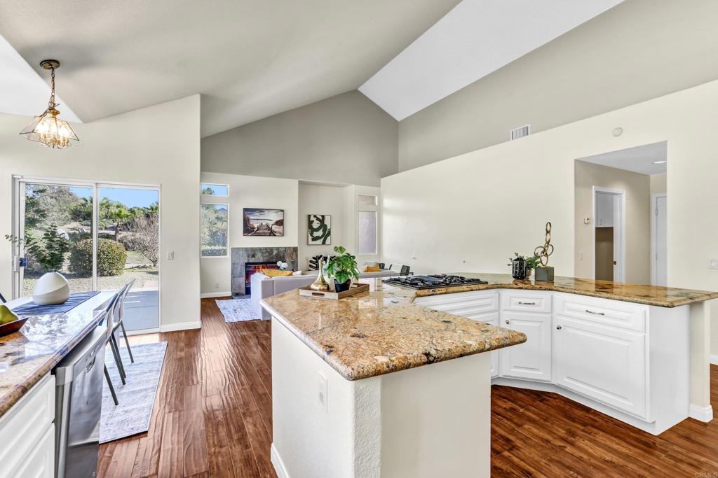 12236 Malabar Drive Poway, CA 92064 - Photo 14 of 32 a kitchen with granite countertop kitchen island wooden floor center island and stainless steel appliances