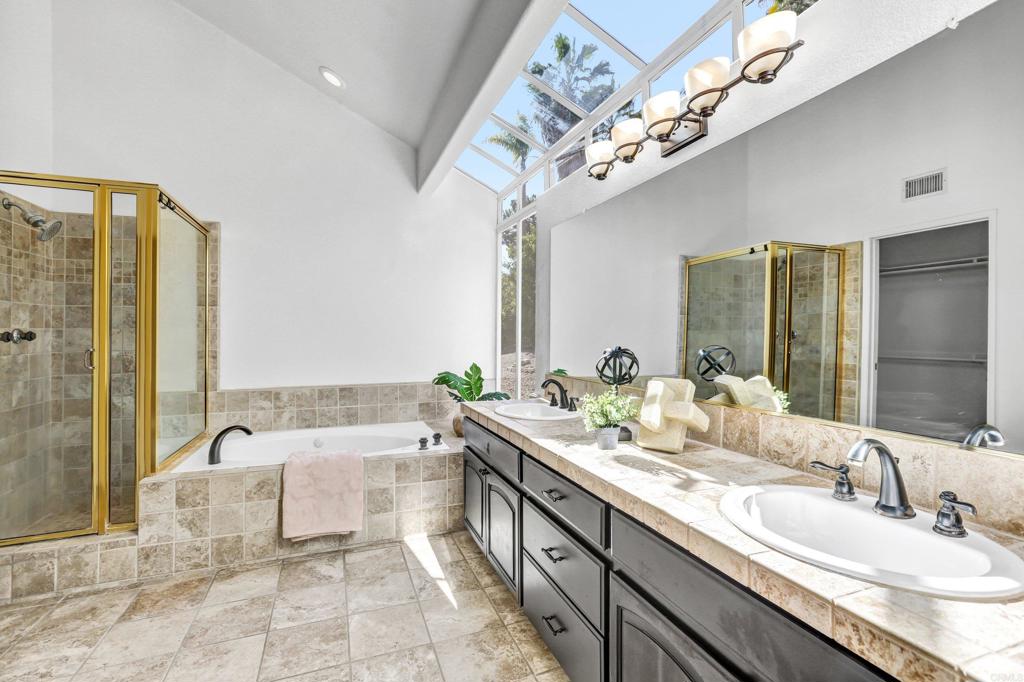 12236 Malabar Drive Poway, CA 92064 - Photo 19 of 32 a spacious bathroom with a double vanity sink a mirror and a bathtub