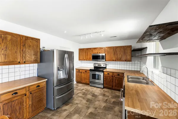 a kitchen with stainless steel appliances granite countertop a refrigerator stove and oven