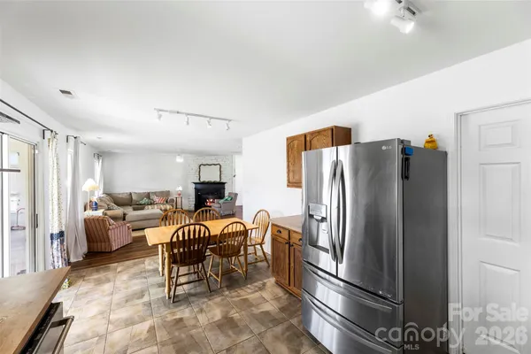 a living room with furniture and a refrigerator