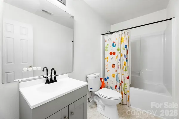 a bathroom with a sink a toilet and a shower curtain