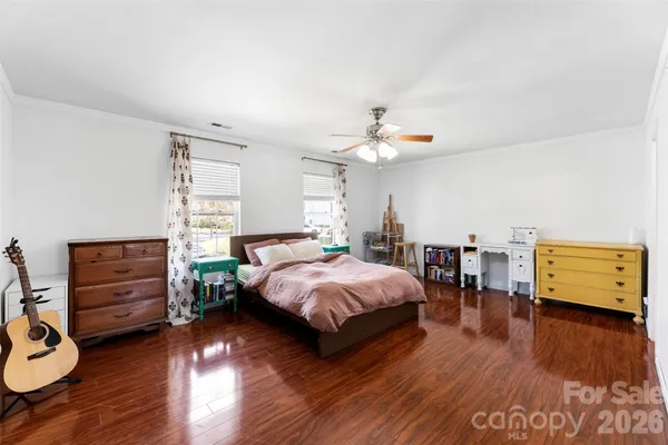 a bedroom with a bed and wooden floor