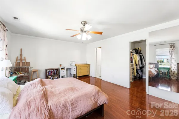 a spacious bedroom with a bed and a chandelier