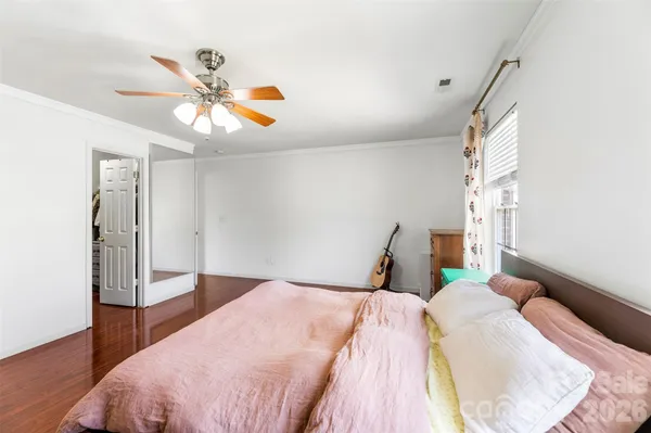 a bedroom with a bed and wooden floor
