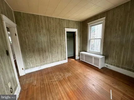 a view of a room with wooden floor and windows