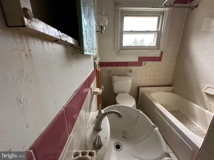 a bathroom with a tub sink and toilet