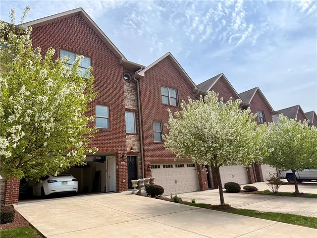 a view of an empty room with kitchen and a window