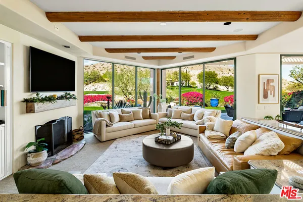 a living room with patio furniture and a floor to ceiling window